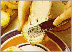 Enfriadas las rebanadas de pan, untarlas por el lado no tostado con un poco de mantequilla.