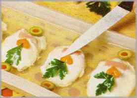 Sacar los huevos del frigorífico y adornarlos con rodajas de zanahorias, hojas de perejil, aceitunas sin hueso cortadas en lonchas y trocitos de jamón cocido.
