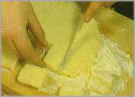Alisar la pasta con un rodillo y cortarla en cuadraditos de unos 5 centímetros.