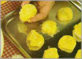 Derretir la mantequilla en una fuente para el horno y poner en ella las patatas. Dejar en el horno hasta que tomen un color dorado uniforme.