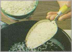 Dorar la cebolla y, pasados unos minutos, añadir el arroz, regarlo con el caldo y dejarlo hacer unos minutos.
