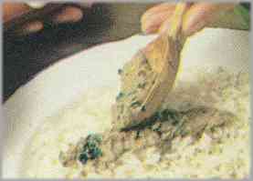 Colocar el arroz en una fuente de servir y cubrir su superficie con la crema de sardinas. Servir caliente.