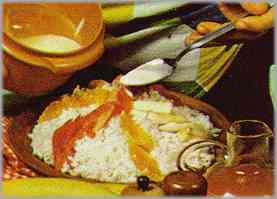 Poner el arroz en una fuente de servir con los tomates, los trozos de plátano, la langosta troceada y trocitos de mandarina.