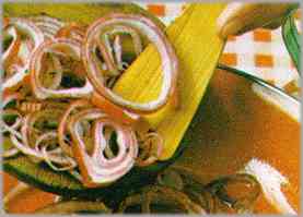 Pelar la cebolla y cortarla en anillos. Poner el aceite en que se frió el bacalao en otra sartén y dorar en ella los anillos de cebolla.