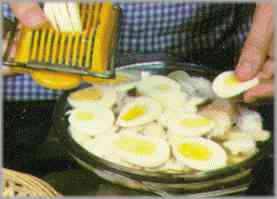 Poner sobre las patatas una capa de bacalao y encima otra con los huevos duros.
