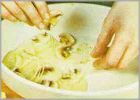 Untar con mantequilla las paredes y el fondo de una fuente para el horno. Poner tres capas de champiñones, patatas y cebolla, respectivamente.