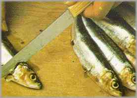 Limpiar las sardinas. Cortar las cabezas y lavarlas con agua fría.
