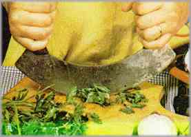 Preparar la salsa con las hierbas como se indica en la receta y verterla sobre las chuletas. Adornar con perejil, limón y tomate.