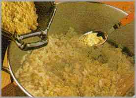 Dejar dorar durante unos minutos y añadir el arroz que se dejará cocer con el caldo (agregándolo poco a poco), a fin de que no se pegue. Añadir al final azafrán y mantener caliente.