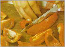 Lavar y quitar a los pimientos las semillas. Cortarlos estrías. Pelar los tomates y cortarlos en cuatro trozos. Pelar la cebolla.