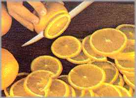 Pesar las naranjas y sin pelarlas, cortarlas en rodajas muy delgadas.