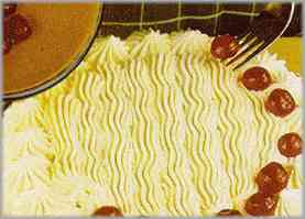 Como decoración de la torta, poner la nata restante con la ayuda de una manga pastelera y algunas cerezas escarchadas.