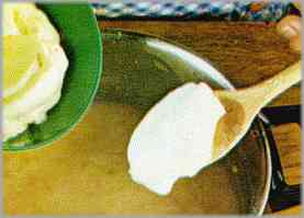 Incorporar la mantequilla, revuelta aparte con 50 gr. de azúcar, y remover con la cuchara de madera.