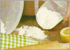 Poner en una superficie lisa la harina, el azúcar, la mantequilla, las yemas de huevo, una pizca de sal y piel de limón rallada.
