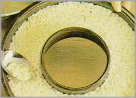 Untar de mantequilla un molde con orificio y verter el arroz, nivelar la superficie con una cuchara.