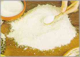 Colocar sobre una superficie lisa 260 gramos de harina, 150 gramos de azúcar y 130 gramos de mantequilla blanda.