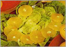Forrar una fuente de servir con las hojas de lechuga y colocar sobre ellas las naranjas cortadas en delgadas rodajas.