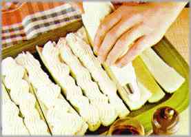 Preparar la salsa. Remover hasta obtener una crema espesa y distribuirla, utilizando una manga pastelera.