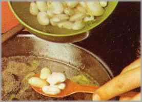 Completar con las judías blancas, salar y condimentar con pimienta. Dejar hacer un par de horas a fuego lento y con la tapa puesta.