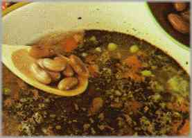 Cubrir todo con tres litros de caldo y tras añadir los guisantes salpimentar y dejar hacer a fuego lento un cuarto de hora.