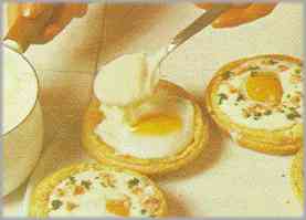 Poner también en cada una un huevo pasado por agua y semicubrirlos con la bechamel.
