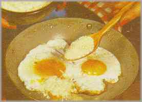 Espolvorear sobre los huevos dos cucharadas de queso rallado. Tapar la sartén y dejarla así unos minutos.