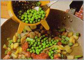 Poner los guisantes en la sartén y añadir la salsa de tomate concentrado.