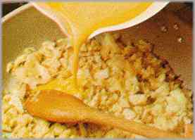Verter el batido de huevos en la misma sartén con la coliflor y rehogar.