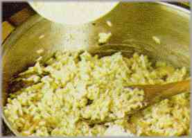 Cuando el arroz esté listo, condimentarlo con una abundante rociada de queso parmesano rallado.