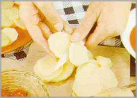 Pelar las patatas, lavarlas y cortarlas en rebanadas de medio centímetro de grosor, aproximadamente.