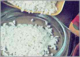 Hervir mientras tanto el arroz y pasarlo a una fuente para el horno untada con mantequilla y espolvoreada con el pan rallado. Formar una cavidad en el centro.