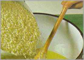 Sofreír la cebolla con 50 gramos de mantequilla. Añadir el arroz y dejarlo tostar.