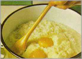 Cuando el arroz esté listo, incorporar la mantequilla restante y las yemas de los huevos.