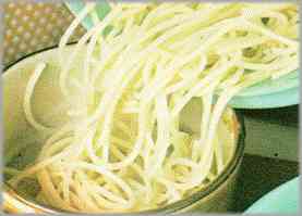 Mientras tanto, hervir los espaguetis con abundante agua con sal, escurrirlos apenas cocidos y pasarlos a una fuente honda de servir.