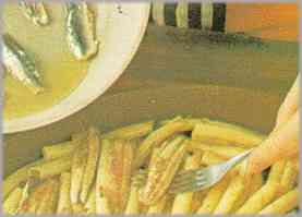 En una fuente para el horno, colocar la mitad de los macarrones. Sobre éstos, verter las anchoas y los tomates hervidos.