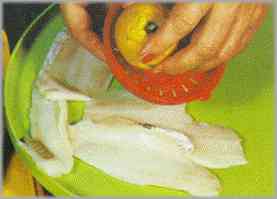 Poner los filetes de pescado en un plato y regarlos con el zumo de limón. Salarlos convenientemente.