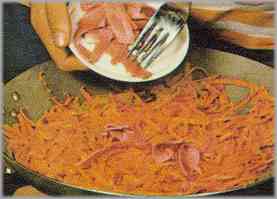 Dorar las zanahorias. Añadir el jamón, salpimentar y dejar que cueza regándolo con dos cucharas de caldo.