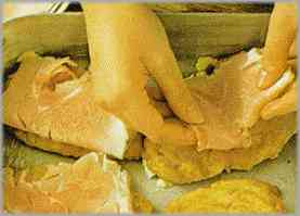 Poner encima de cada filete una loncha de jamón de York doblada y otra de queso Emmental.