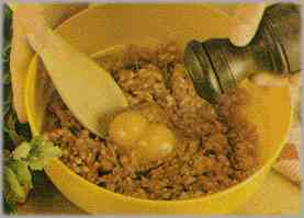 Poner la carne picada en un recipiente y combinarla con la yema de un huevo. Condimentar con sal, pimienta y nuez moscada. Amasar y pasar este preparado sobre la gallina abierta.