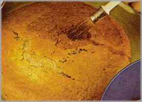 Sacar la tarta del horno tras 40 minutos a 150 grados y untar con un pincel el sirope. Cortar la torta en dos discos iguales.
