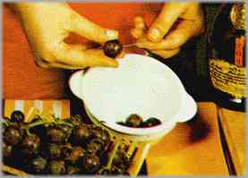 Preparar el hojaldre según se indica más arriba y meterlo en el horno durante 20 minutos. Mientras, perforar las uvas con un alfiler y ponerlas a remojo en un recipiente con un poco de coñac y el azúcar.