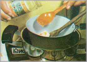 Mezclar la mantequilla con el azúcar, el huevo y la miel, en una cacerola pequeña que se colocará dentro de otra más grande con agua.