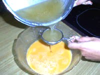 Batir en un cuenco las yemas con los huevos enteros e incorporar el almibar ya preparado a través de un colador, es importante que el almibar no esté muy caliente.