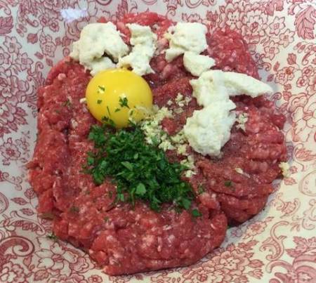 acer las albóndigas con la carne de ternera y de cerdo, el pan, la yema de huevo, un diente ajo picado muy fino y 30 g de perejil.