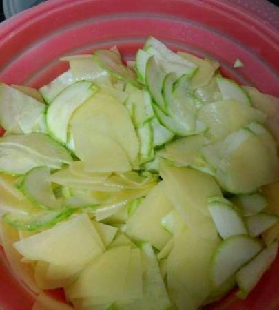 Pelar el calabacín y las patatas y picarlos en triángulos finos. Añadir 1 cucharada de aceite de oliva, sal y mezclar todo. Poner en un recipiente apto para microondas. Puedes añadir cebolla si te gusta.